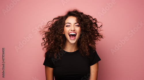 Happy wonderful young woman with long curly hair excited isolated on pink background photo