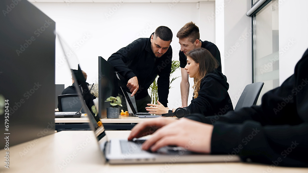 Group of businesspeople, mates involved in teamwork use laptop, look at device screen, consider new business program, corporate software, look interested, engaged in collaborative project discussion - obrazy, fototapety, plakaty 