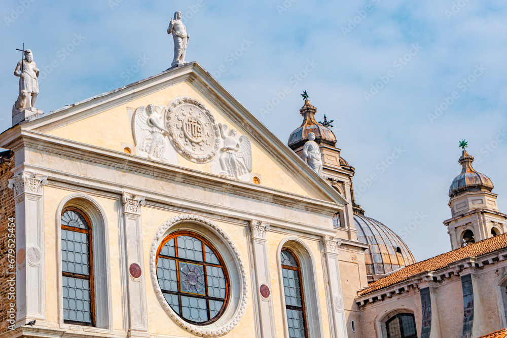 Venice, Italy. Ancient roof statues at facade Chiesa di Santa Maria della Visitazione Church at sunny day and blue sky