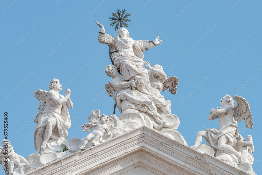 Venice, Italy. Beautiful angels with wings and Saint Maria statues at the roof of Church Chiesa di Santa Maria Assunta, Baroque catholic church with sacred medieval art