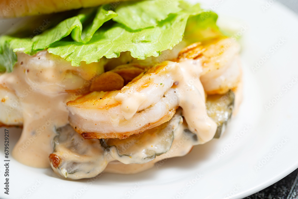 Shrimp burger with cream sauce on a plate