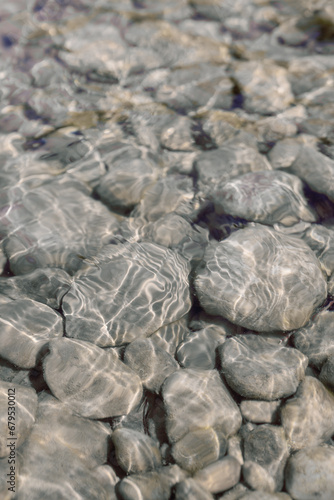 Принти на полотні Rocks glimmering in the sun of a peaceful crystal clear river