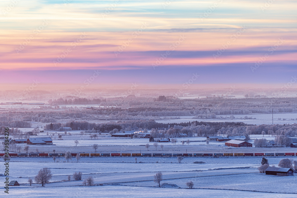 Wintry countryside view at dusk with a train