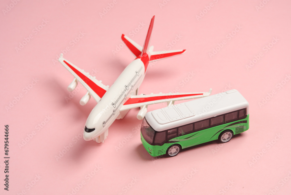 Toy bus miniature and air plane on a pink background.Travel concept