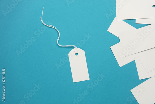 Set of blank white tags with ropes on blue background. Mock up, Template for design. Copy space. Sale, shopping concept