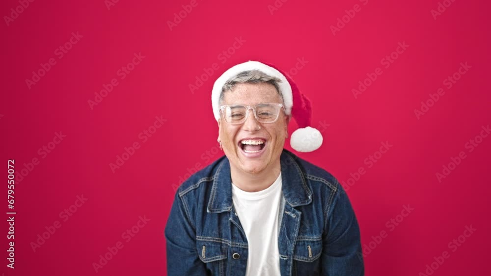 Young caucasian man wearing christmas hat with winner gesture over isolated red background Young caucasian man wearing christmas hat with winner gesture over isolated red background