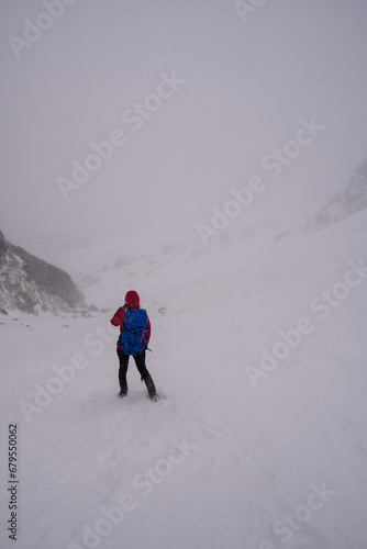 Men with backpack hiking on mountain in snow. Fight for survival in winter mountains. Hiker standing on top of a mountain. Dramatic scenery. Carpathian, Tatras , Europe. Beauty world.