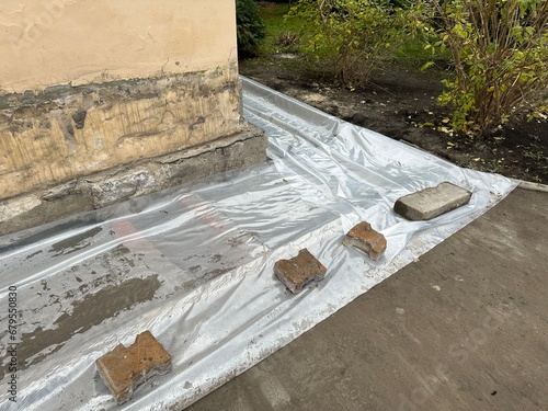 Poured foundation covered with membrane. Liquid cement dries under plastic membrane