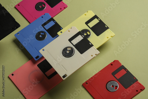 Floating colored retro 80s floppy disks on a green background. Conceptual pop, creative layout