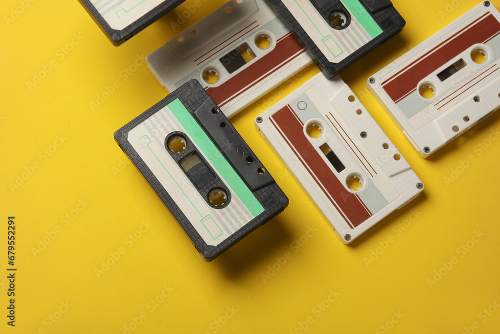 Floating retro 80s audio cassettes on a yellow background. Conceptual pop, creative layout. Minimalism Floating retro 80s audio cassettes on a yellow background. Conceptual pop, creative layout. Minimalism