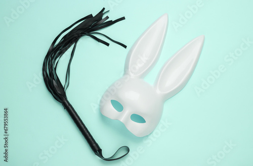 Sex shop toys. Rabbit mask with leather whip on blue background