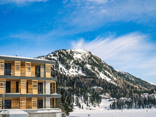 Facade of a hotel with balconies in a ski resort, winter, alps, mountain peak