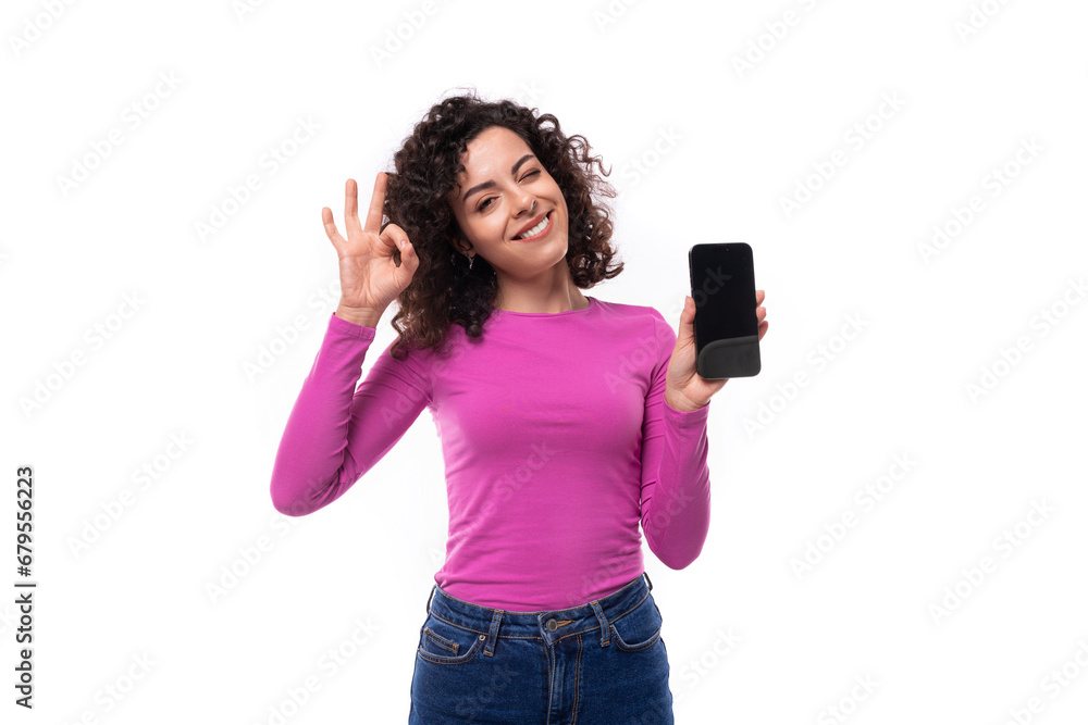 young curly promoter woman dressed in a lilac turtleneck shows the smartphone screen young curly promoter woman dressed in a lilac turtleneck shows the smartphone screen