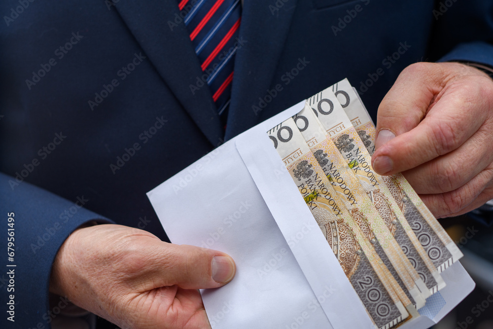 Polskie pieniądze banknoty pln w kopercie trzymane przez elegancko ubranego mężczyznę  - obrazy, fototapety, plakaty 