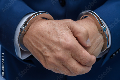 Dłonie starszego oskarżonego mężczyzny skute kajdankami z bliska, przestępca 