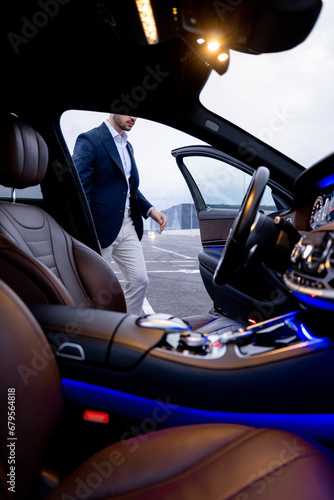 Businessman get in luxury car, view from vehicle interior. Business transportation and lifestyle © rh2010