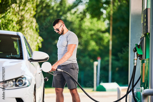 Photography Driver with gasoline pump refilling car gas tank