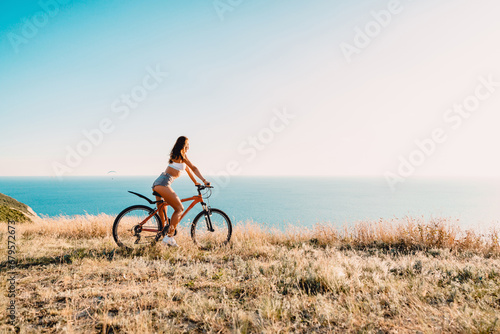Fototapeta Naklejka Na Ścianę i Meble -  Sporty attractive woman with bicycle in outdoor. Lifestyle with young lady..