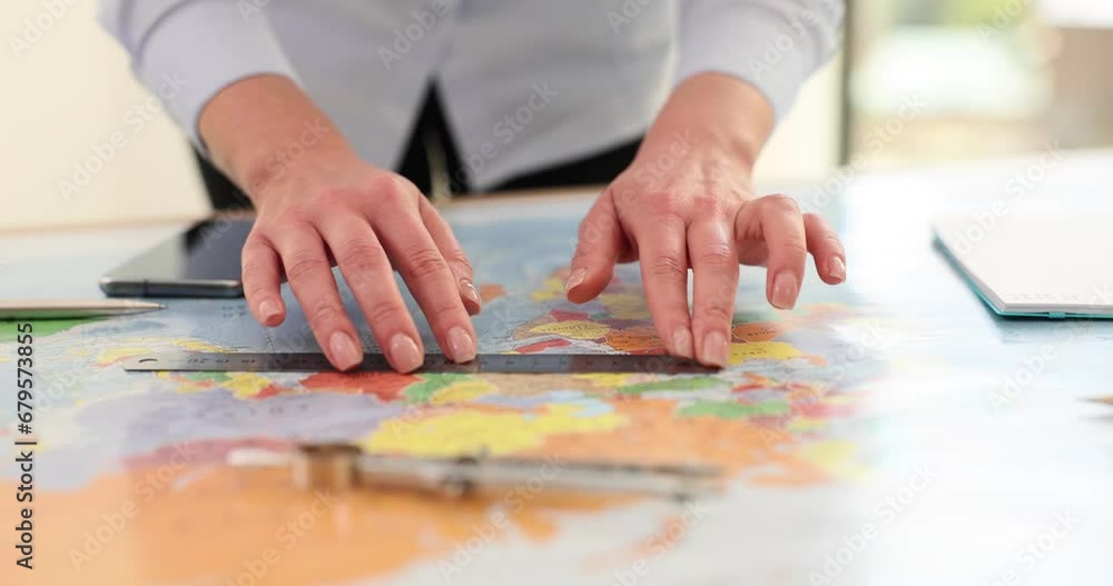 Woman with ruler takes measurements on world map Woman with ruler takes measurements on world map