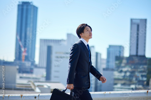 スーツを着た若いビジネスマンと町並み