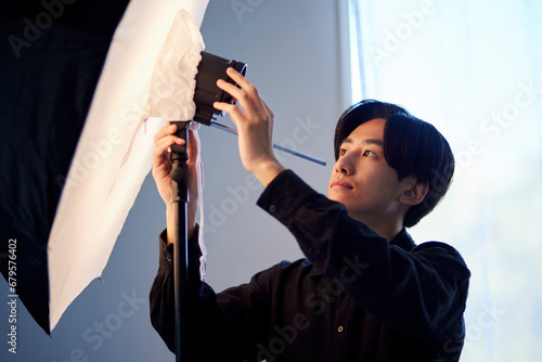 写真スタジオにてストロボの調整を行う日本人フォトグラファーの男性 photo