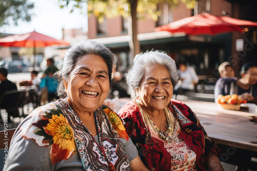 Two happy elderly latina indigenous women spending time together outdoors on a sunny day. photo