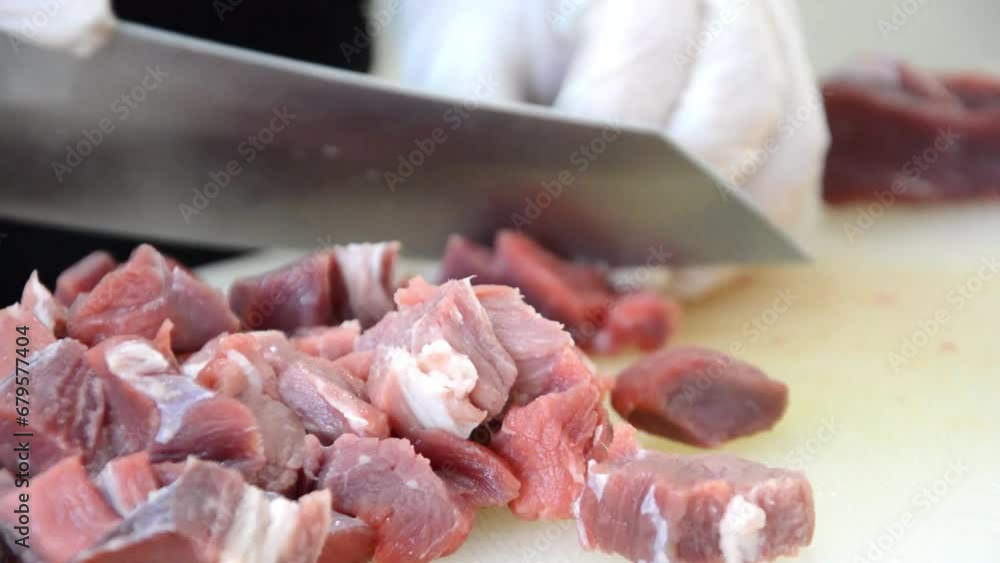 Woman chopping red meat in the kitchen for cooking Woman chopping red meat in the kitchen for cooking