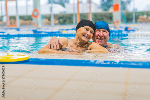 senior couple relaxing in the pool and hugging each other, elderly love concept. High quality photo