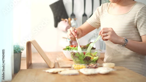 Woman making a salad in kitchen. photo