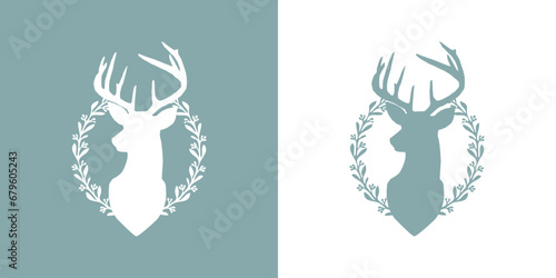 Logo con silueta de cabeza de reno o ciervo con corona navideña de hojas y bayas de acebo para tarjetas y felicitaciones	 photo