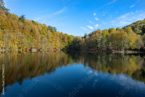 Fototapeta Naklejka Na Ścianę i Meble -  Yedigöller or Seven Lakes National Park is in Turkey.
Reflection of a lake with trees and blue sky in autumn colors. Yedigöller, Bolu.
Yedigöller in autumn. Bolu, Türkiye.