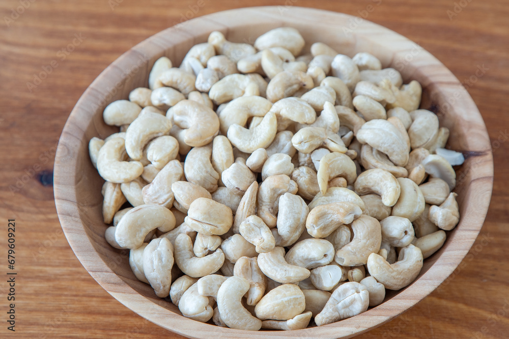 Cashews in a wooden bowl. Nuts are healthy food. Wooden background. Cashew kernel Cashews in a wooden bowl. Nuts are healthy food. Wooden background. Cashew kernel