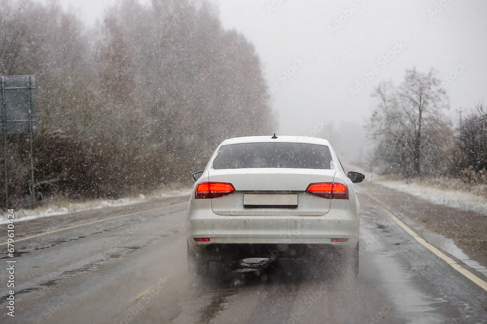 Car on the road in the first days of winter and frost rear view Car on the road in the first days of winter and frost rear view
