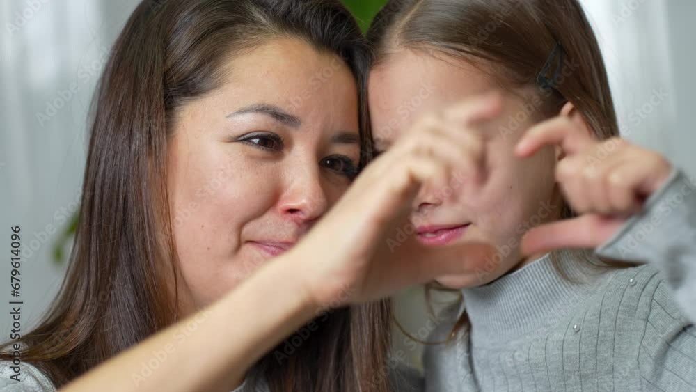 Happy mother and little daughter making heart with joined fingers Happy mother and little daughter making heart with joined fingers
