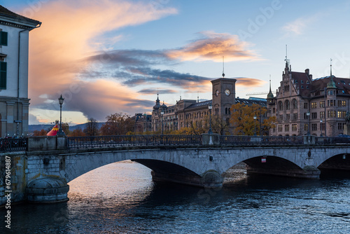 Riverside view of Münsterbrücke or Munsterbridge in Zurich city Switzerland. Vide angle view, sunset dramatic cloudscape, no people photo
