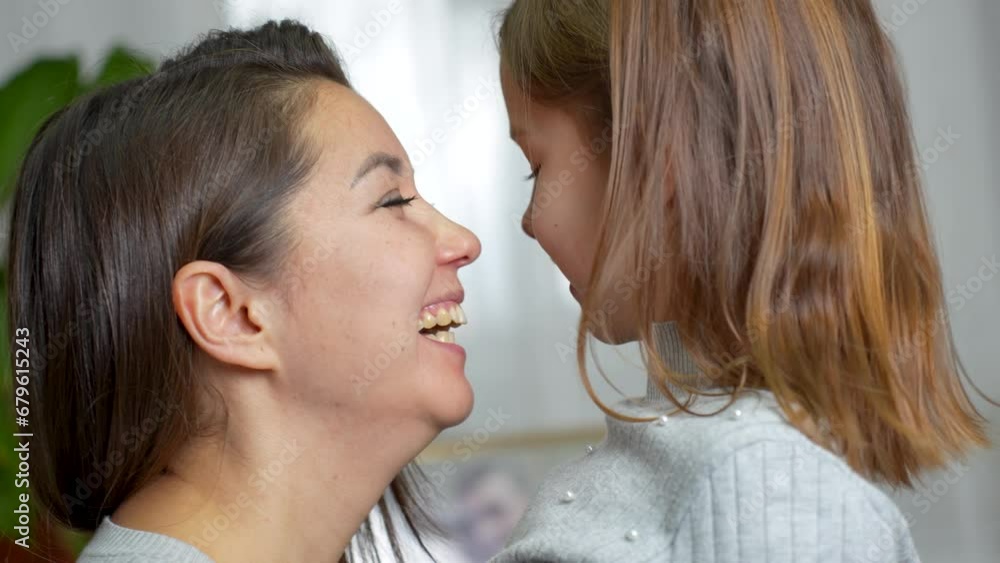 Happy young mother and cute daughter playing together touching nose Happy young mother and cute daughter playing together touching nose
