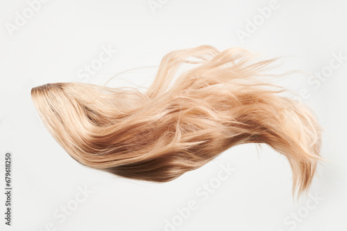 Natural looking shiny hair, fair blonde curls isolated on white background with copy space