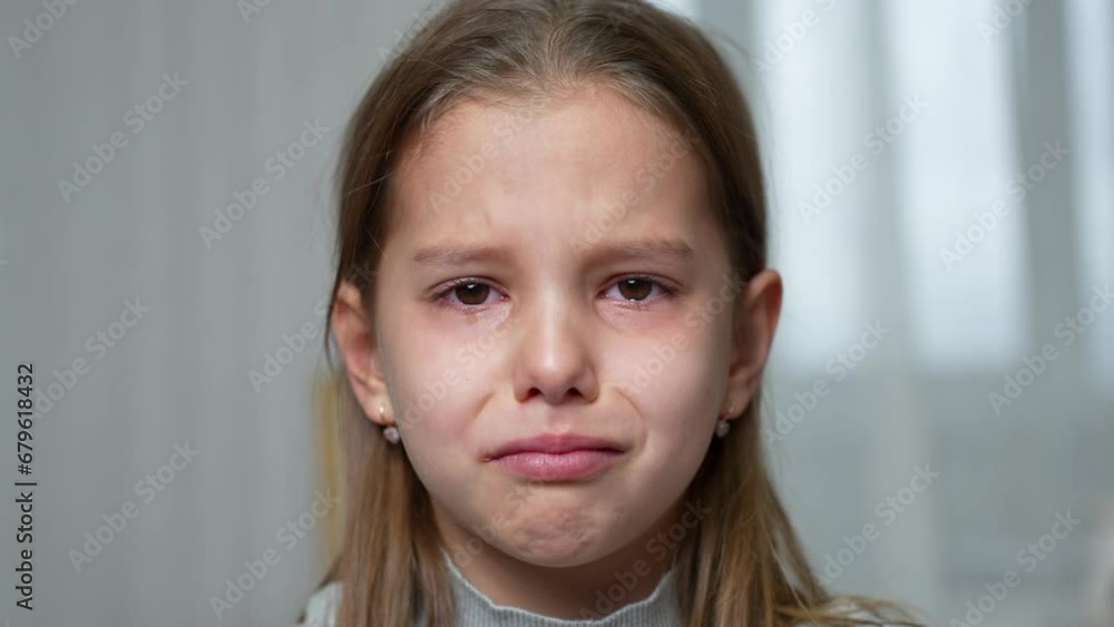 Crying little girl with teddy bear toy sitting in sofa Crying little girl with teddy bear toy sitting in sofa