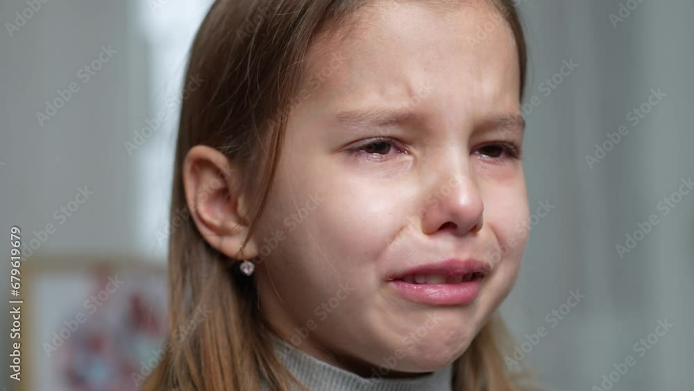 Crying little girl with teddy bear toy sitting in sofa Crying little girl with teddy bear toy sitting in sofa
