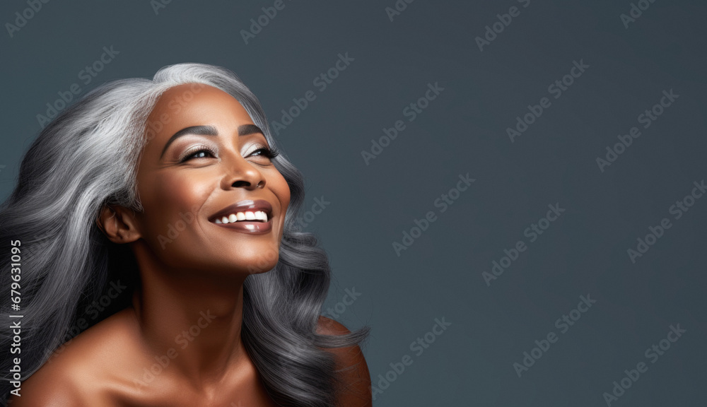 Fototapeta premium Portrait of an elegant mature woman with smooth healthy skin, long gray hair, and a joyful smile. Cosmetics and beauty advertising.
