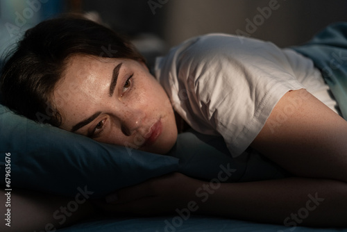 Sleep disorder, insomnia. Young woman lying on the bed awake at late night. Can not sleep