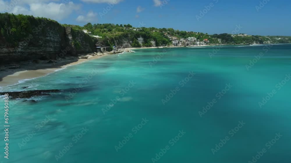 Popular beach in Bali with surfers in blue ocean. Vacations in tropics. Aerial view Popular beach in Bali with surfers in blue ocean. Vacations in tropics. Aerial view