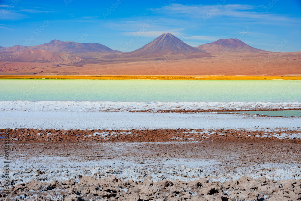 Laguna Tebenquiche, um lago de sal com cores vibrantes azul, verde e amarela ao lado do vulcão Licancabur. Laguna Tebenquiche, um lago de sal com cores vibrantes azul, verde e amarela ao lado do vulcão Licancabur.