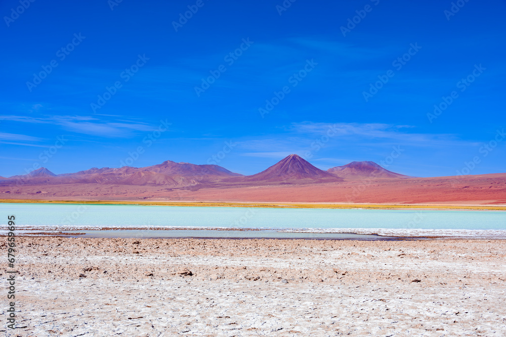 Laguna Tebenquiche, um lago de sal com cores azul, verde e amarela ao lado do vulcão Licancabur. 