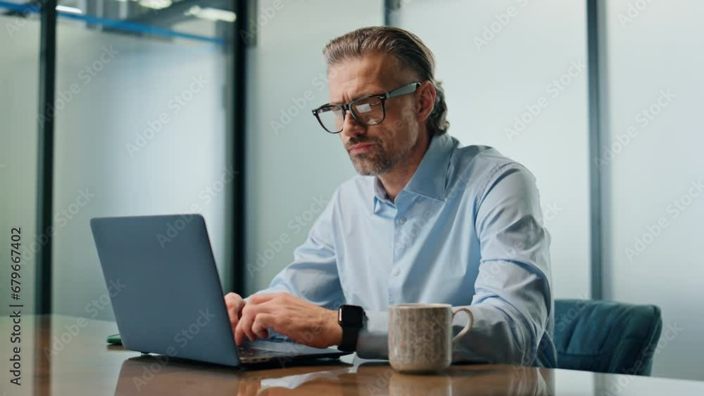 Focused businessman texting laptop at office closeup. Eyeglasses ceo man working Focused businessman texting laptop at office closeup. Eyeglasses ceo man working