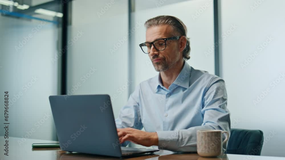 Overworking man drinking coffee in evening office. Businessman typing laptop Overworking man drinking coffee in evening office. Businessman typing laptop