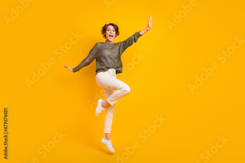 Photo of positive glad good mood girl celebrating party presenting empty space isolated on yellow color background