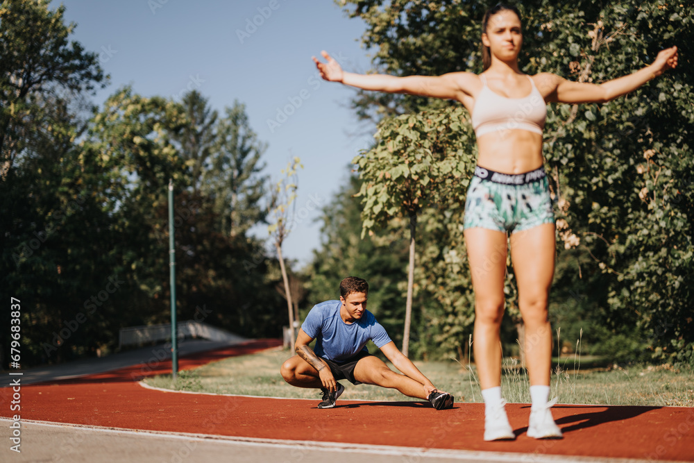Caucasian couple workout outdoors in park, stretching and warming up. Sportsmanship and motivation lead to positive results for fit body, healthy lifestyle.