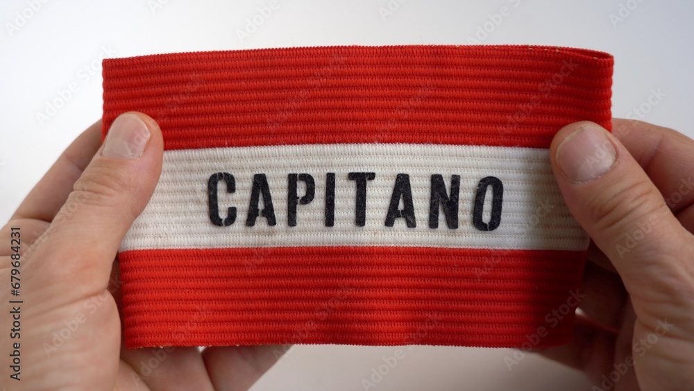 Man's hands hold football captain's armband and cup won when he was a child in childhood - remembering past successes that led to becoming adults and growing self-esteem