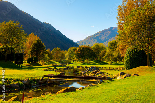 Golf Course with a River and Mountain in a Sunny Autumn Day in Losone, Switzerland. photo